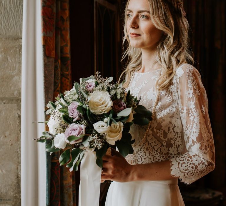 Bride in Lace Top Holding in a Cream and Purple Bouquet