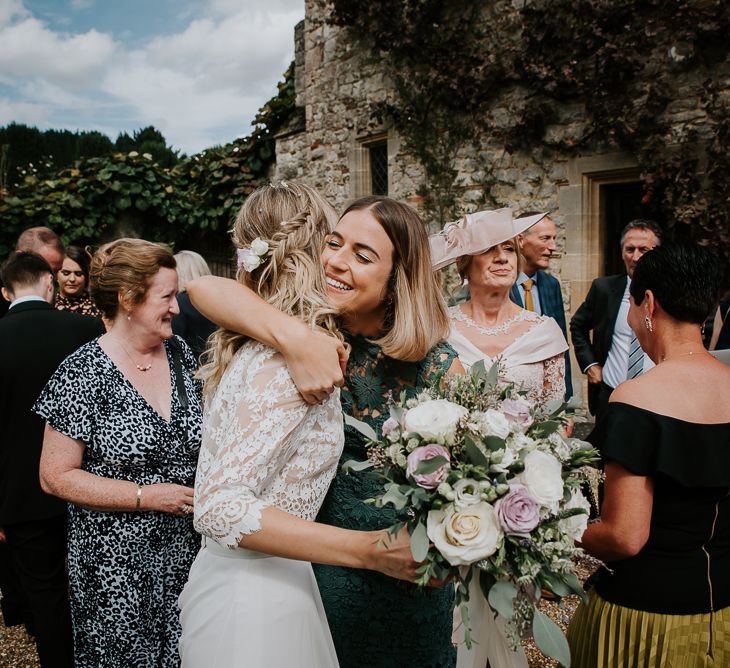 Wedding Guest in Forest Green Dress Hugging the Bride