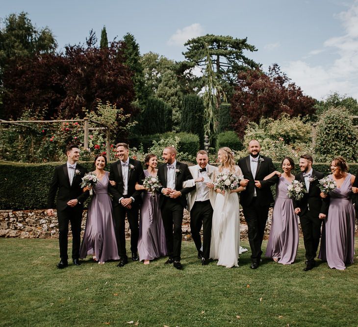 Sophisticated Wedding Party in Black Tuxedos and Purple Bridesmaid Dresses