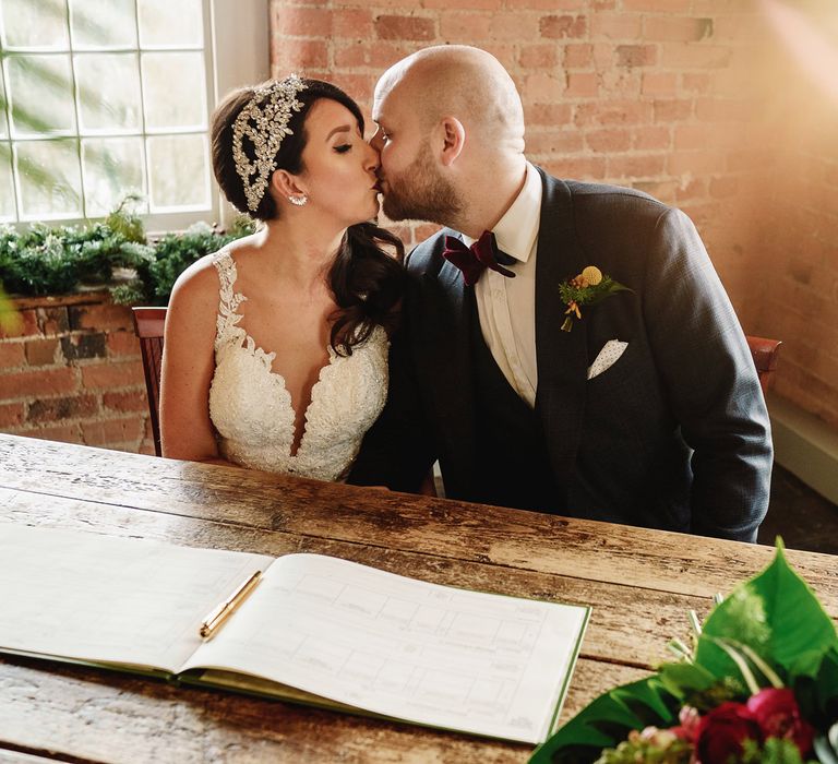 Bride in Martina Liana Lace Wedding Dress and Groom in Tom Ford Suit  Signing The Register