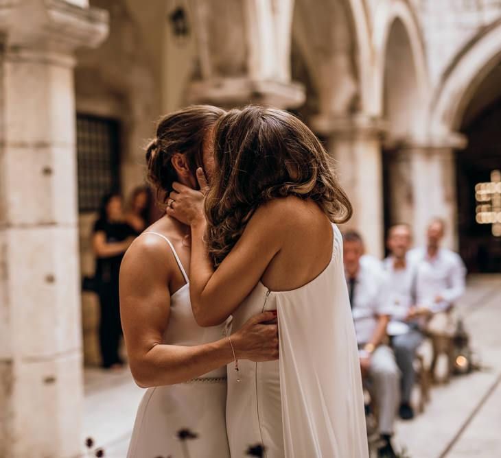 Bride in high low wedding dress kisses new wife