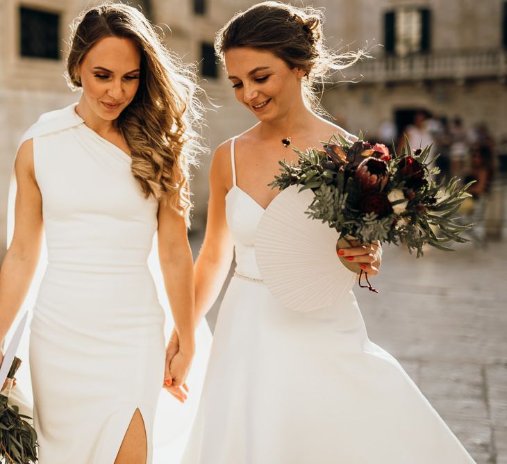 Bride in high low wedding dress carries bouquet