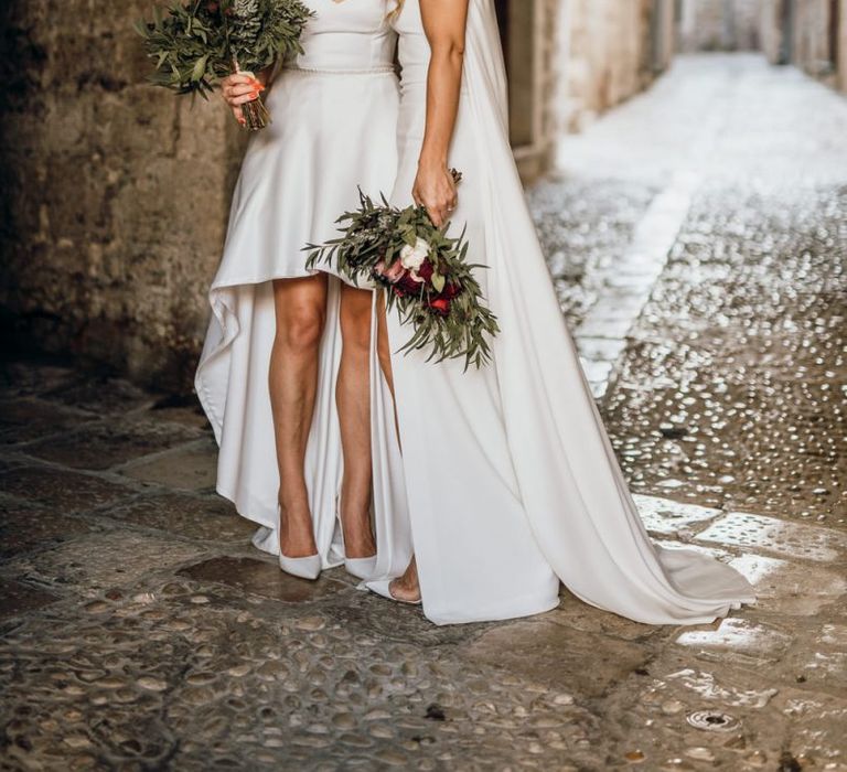 Brides in bespoke dressed with high low wedding dress and bridal cape