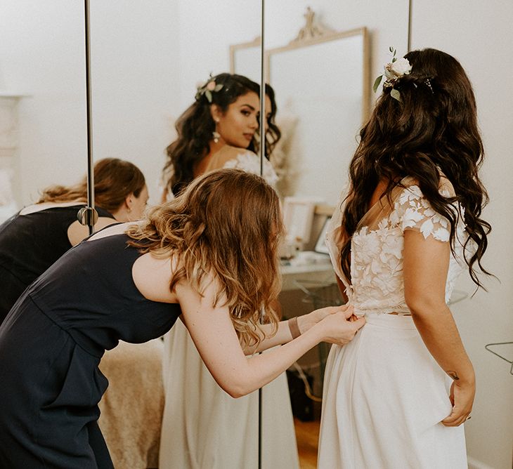 Bride putting on lace top bridal separates with flower hair decoration