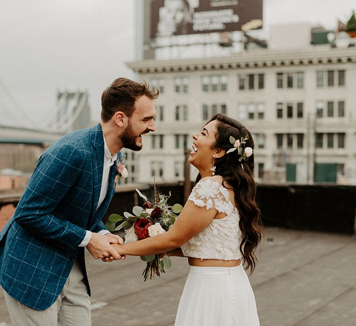 Bride and Groom first look moment on rooftop building with Manhattan skyline and king protea bouquet