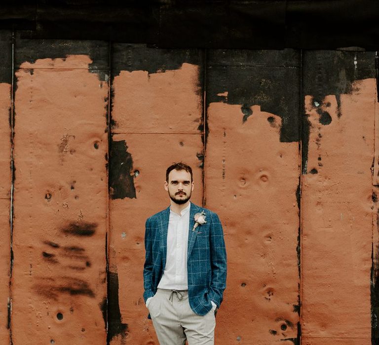 Groom  wearing a checked blue blazer and white trainers