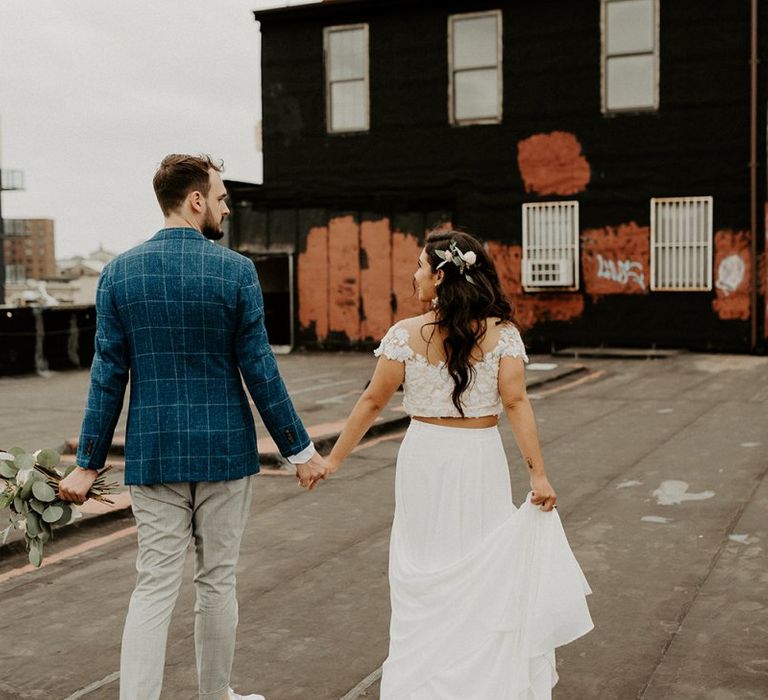 Bride and Groom first look moment on rooftop building with Manhattan skyline and back of bridal separates