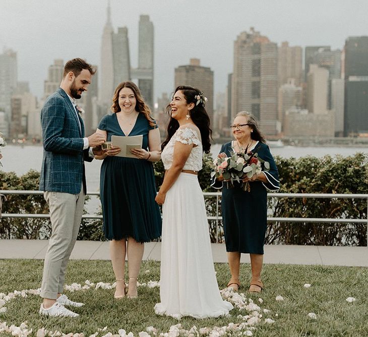 Bride and groom tie the knot at a park overlooking the East River and the NYC skyline with bridal separates