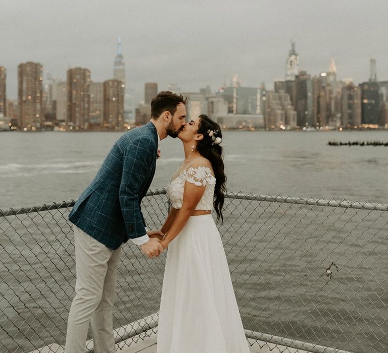 Bride and groom embrace with the NYC skyline backdrop