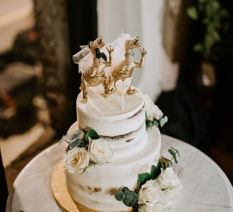 Semi naked wedding cake with dinosaur cake topper