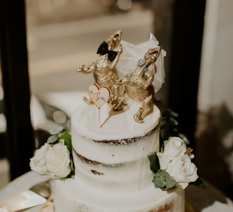 Semi naked wedding cake with personalised dinosaur cake topper