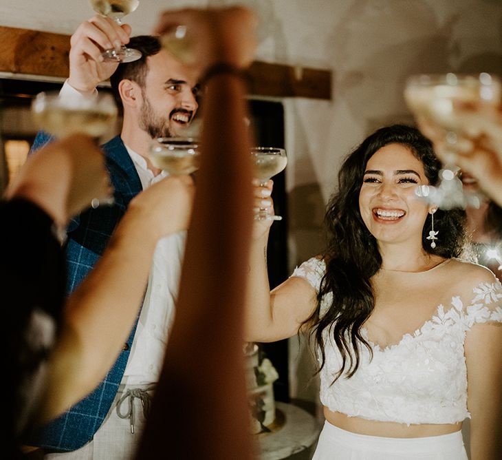 Bride and groom raise a glass with their closest friends and family