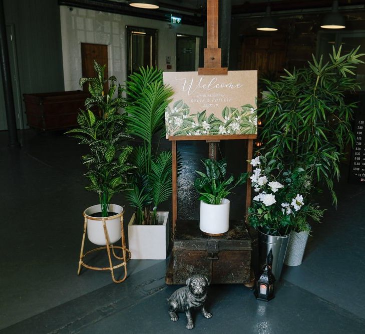 Wedding welcome sign surrounded by foliage and customised neon sign