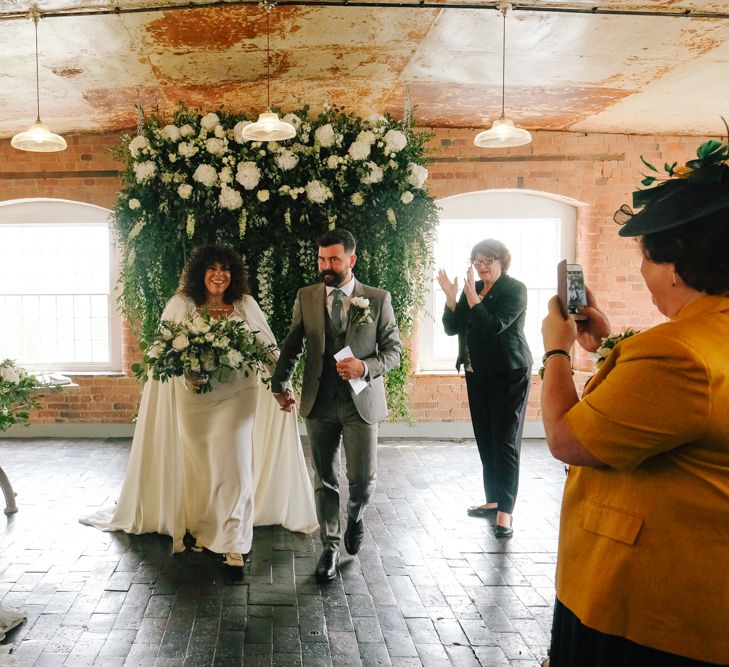 Black bride in wedding cape walking down the aisle