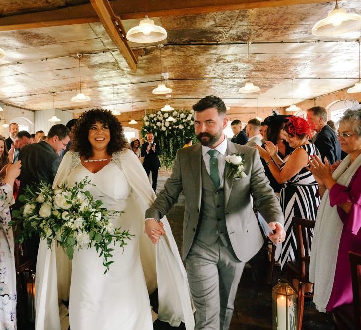 Bride and groom as husband and wife at industrial wedding with customised neon sign