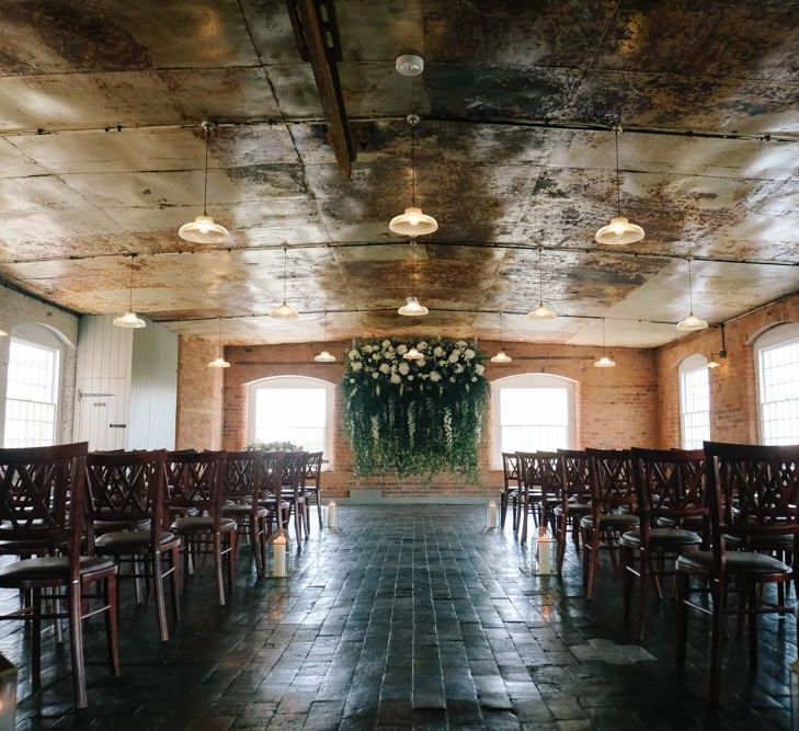 Industrial style ceremony space with floral installation