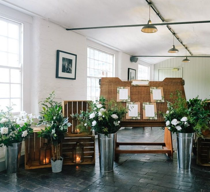 Wedding seating plan sign surrounded with foliage decor