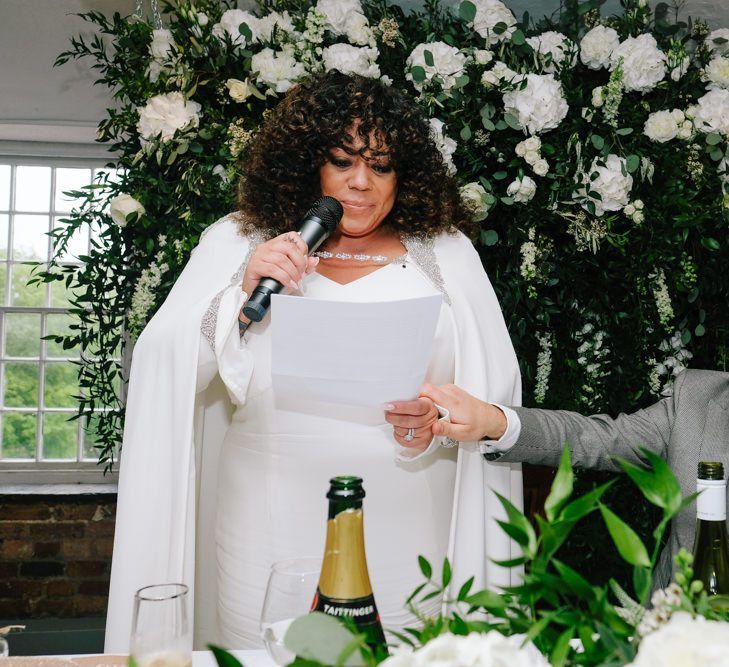 Bride in bridal cape makes wedding speech