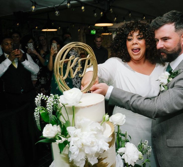 Bride and groom cut the gold detailed wedding cake