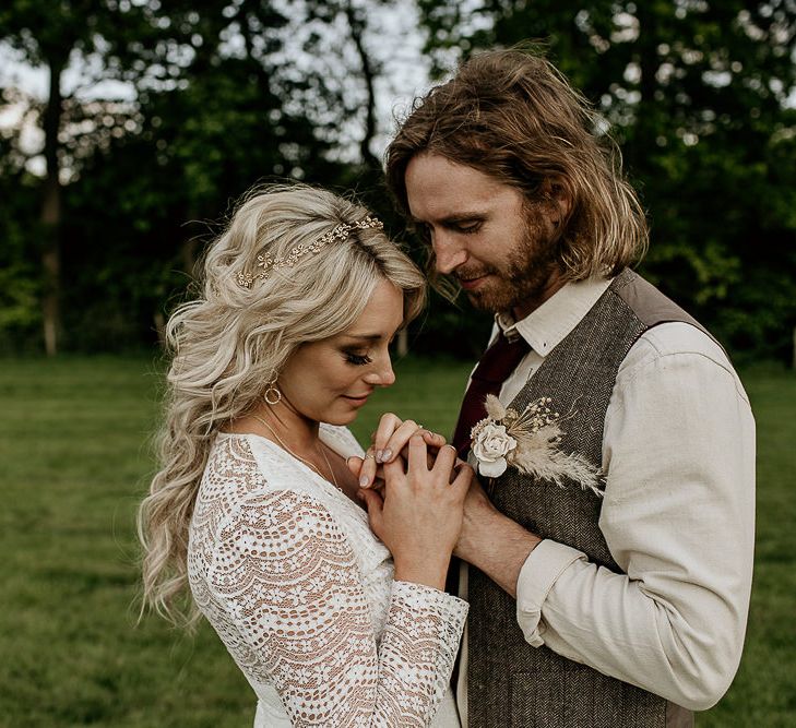 Boho Bride in Lace Wedding Dress with Long Sleeves and Groom in Waistcoat Holding Hands