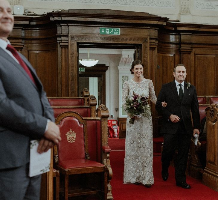 Entrance of the Bride | Beaded Needle &amp; Thread Wedding Dress with Long Sleeves | Britten Veil | Maroon and White Bridal Bouquet with Green Foliage | Islington Town Hall | Beaded Needle &amp; Thread Dress for Intimate Islington Wedding | Olivia &amp; Dan Photography