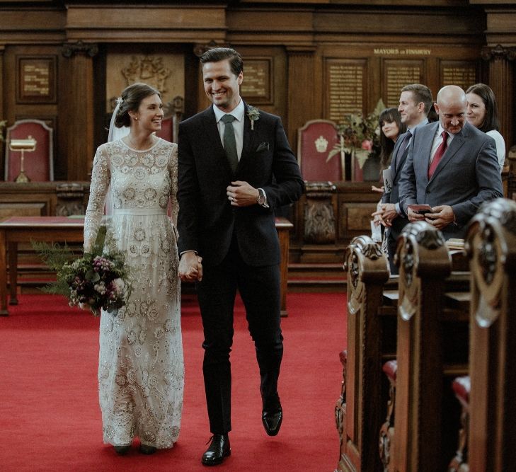 Wedding Ceremony | Bride in Beaded Needle &amp; Thread Wedding Dress with Long Sleeves | Groom in Marks &amp; Spencer Suit with Olive Tie | Britten Veil | Maroon and White Bridal Bouquet with Green Foliage | Islington Town Hall | Beaded Needle &amp; Thread Dress for Intimate Islington Wedding | Olivia &amp; Dan Photography