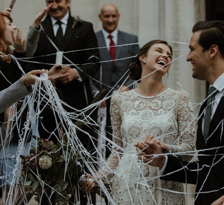 Just Married | Bride in Beaded Needle &amp; Thread Wedding Dress with Long Sleeves | Groom in Marks &amp; Spencer Suit with Olive Tie | Britten Veil | Maroon and White Bridal Bouquet with Green Foliage | Islington Town Hall | Beaded Needle &amp; Thread Dress for Intimate Islington Wedding | Olivia &amp; Dan Photography