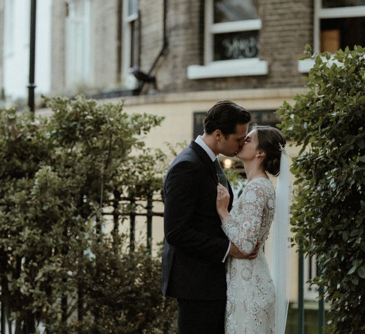 Bride in Beaded Needle &amp; Thread Wedding Dress with Long Sleeves | Groom in Marks &amp; Spencer Suit with Olive Tie | Britten Veil | Tania Maris Hairpiece | Beaded Needle &amp; Thread Dress for Intimate Islington Wedding | Olivia &amp; Dan Photography