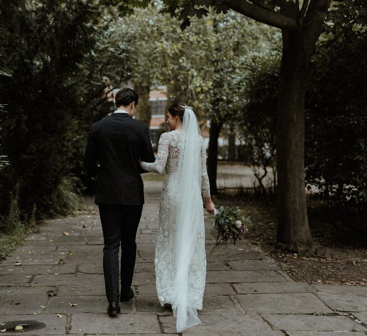 Bride in Beaded Needle &amp; Thread Wedding Dress with Long Sleeves | Groom in Marks &amp; Spencer Suit with Olive Tie | Britten Veil | Tania Maris Hairpiece | Maroon and White Bridal Bouquet with Green Foliage | Beaded Needle &amp; Thread Dress for Intimate Islington Wedding | Olivia &amp; Dan Photography