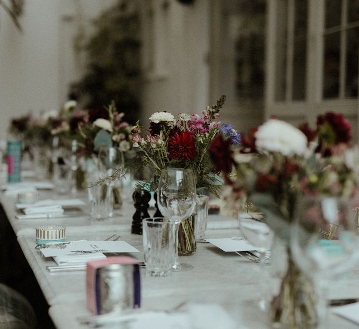 Wedding Reception Decor | Maroon and White Table Flowers with Thistles and Foliage in Mason Jars | Fortnum &amp; Mason Favours | Bourne &amp; Hollingsworth Buildings | Greenhouse Reception Venue | Beaded Needle &amp; Thread Dress for Intimate Islington Wedding | Olivia &amp; Dan Photography