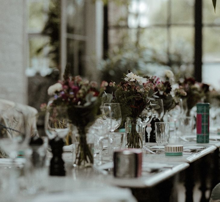 Wedding Reception Decor | Maroon and White Table Flowers with Thistles and Foliage in Mason Jars | Fortnum &amp; Mason Favours | Bourne &amp; Hollingsworth Buildings | Greenhouse Reception Venue | Beaded Needle &amp; Thread Dress for Intimate Islington Wedding | Olivia &amp; Dan Photography