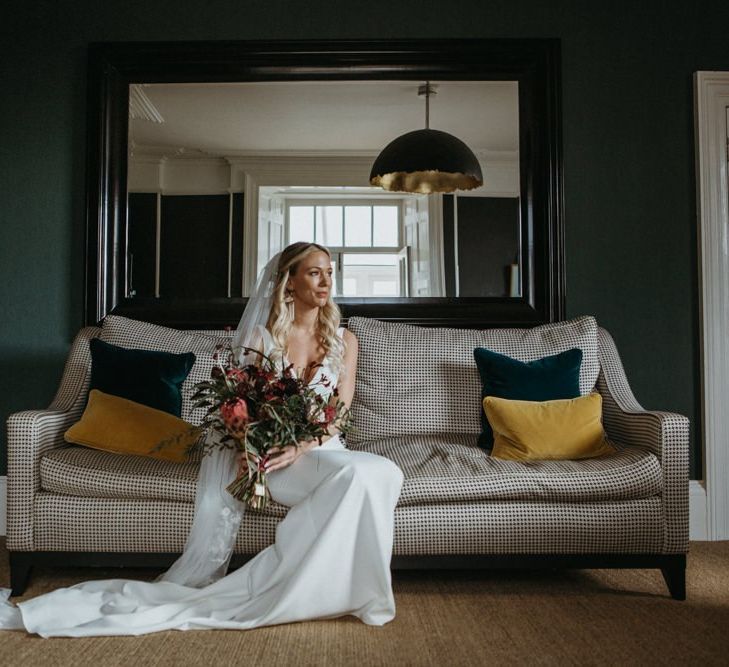 Bride with red floral bouquet at Norfolk wedding with supermarket wedding cake