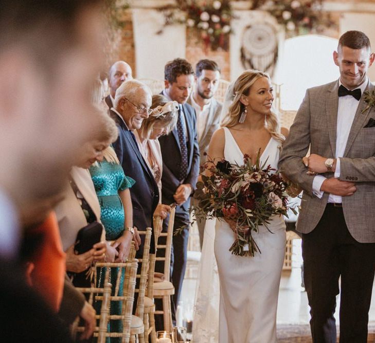 Bride walks down the aisle at rustic ceremony