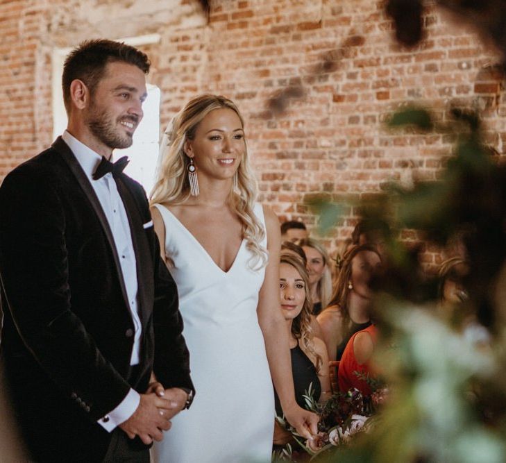 Bride and groom at altar at Norfolk wedding with  supermarket wedding cake