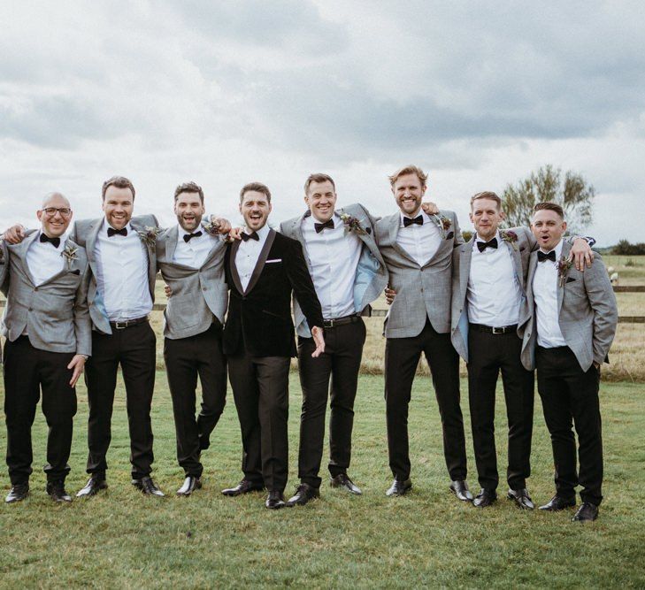 Groomsmen in matching grey dinner jackets and bowties