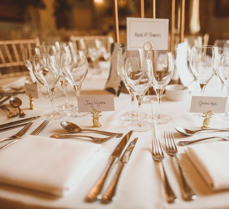 Table decor details with gold pineapple place holders at London celebration