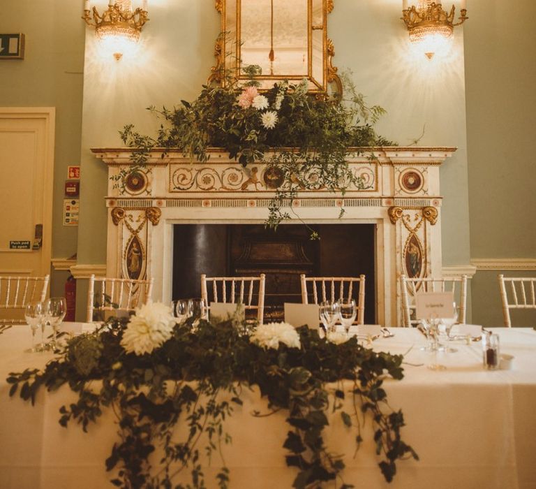 Top table with white floral foliage decor at summer reception in London