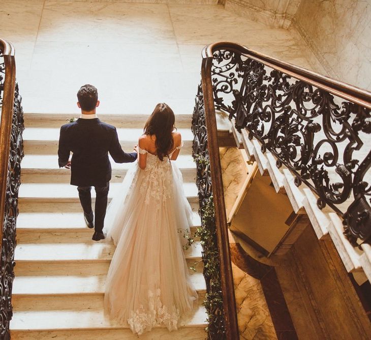 Bride and groom steal a moment on the stairway at Dartmouth House wedding in London