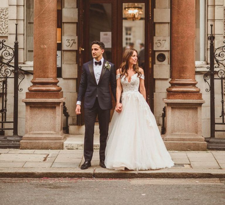 Bride and groom steal a moment wearing Martina Liana dress