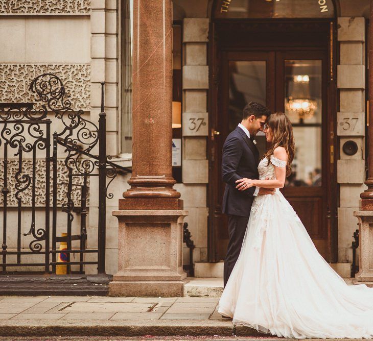 Bride and groom steal a moment wearing Martina Liana off the shoulder laced dress with tulle skirt