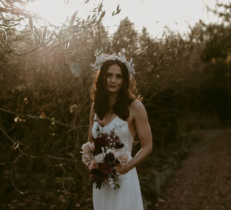 Stylish Bride in Halfpenny London Juniper Dress &amp; Lilly Skirt and Luna Bea Headdress Holding Burgundy and Pink Wedding Bouquet