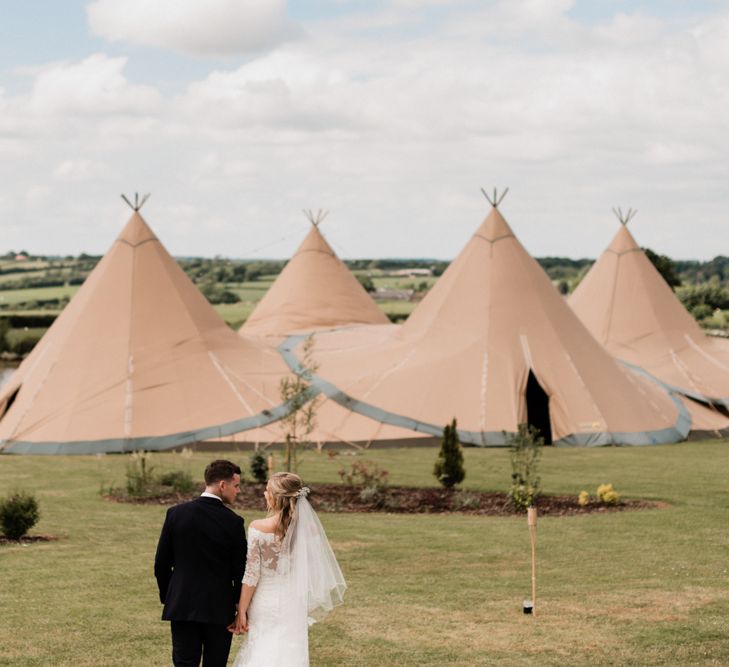 Bride and Groom Standing in Front of Their At Home Tipi Wedding Reception