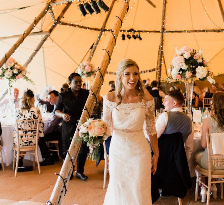 Bride in Lace Bardot Wedding Dress Standing in the Middle of her Rustic Tipi Reception