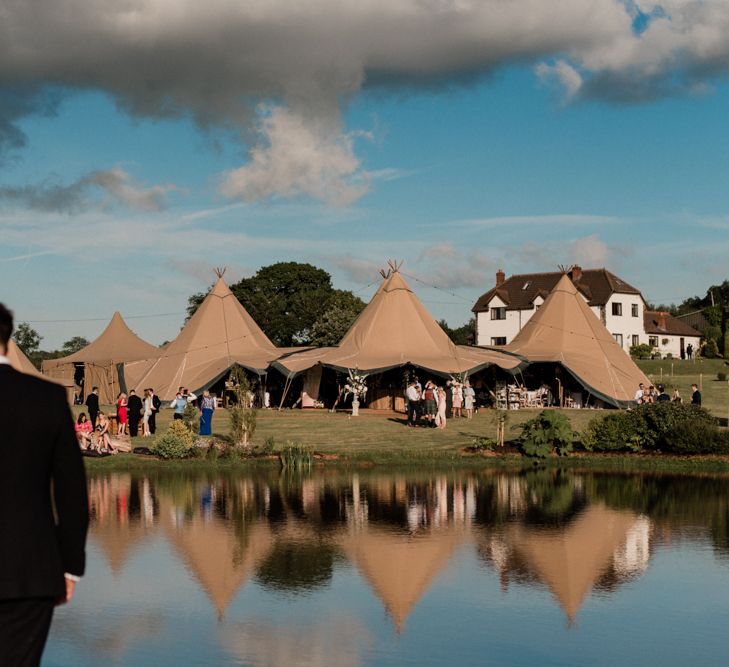 Bride and Groom Kissing in Front of Their At Home Tipi Wedding Reception