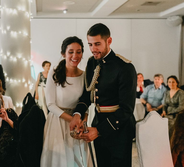 Bride and groom cut the cake with sword