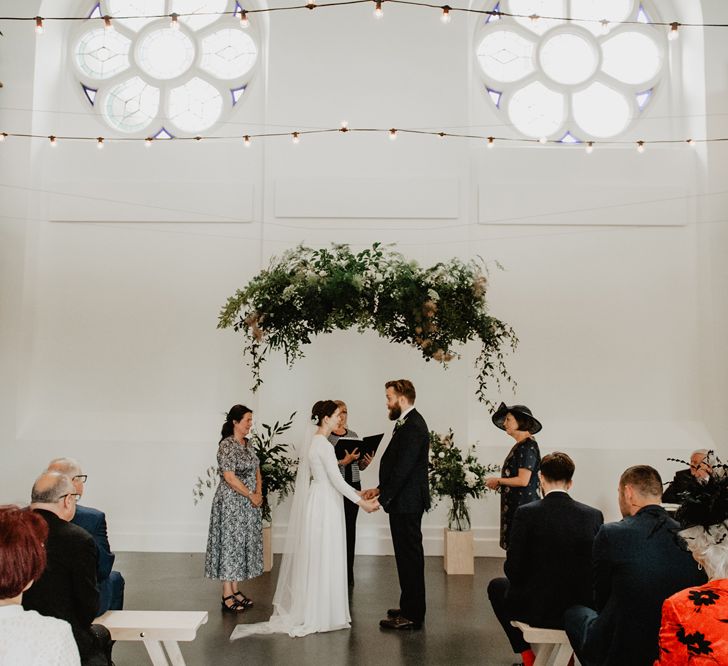 Wedding Ceremony with Hanging Greenery Installation and Fairy Light Wedding Decor