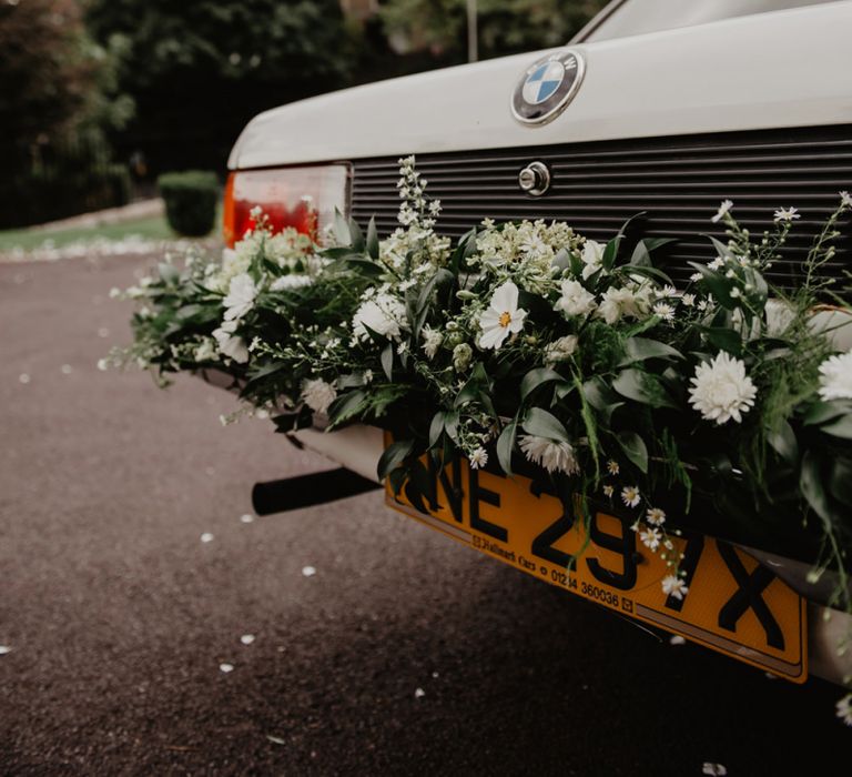 Vintage BMW Wedding Car with White and Green Wedding Flowers Decorating the Bumper