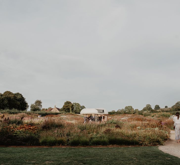 Wedding Guests Walking towards Pod in Field