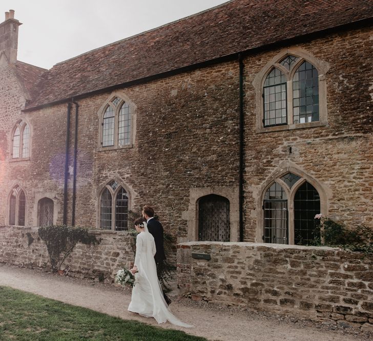 Golden Hour Portrait with Bride in Homemade Wedding Dress with Long Sleeves and Groom in Three-Piece Navy Reiss Suit