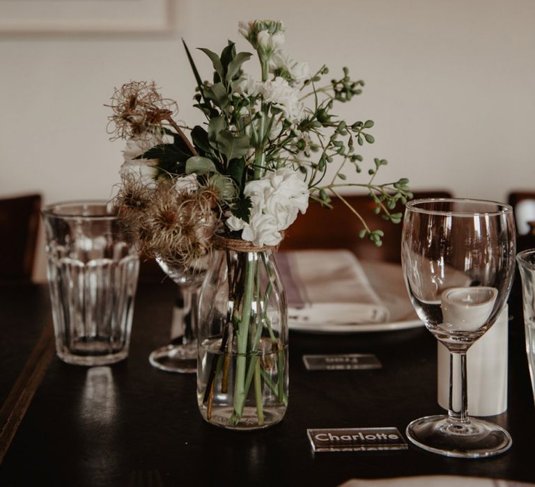 White and Green Wedding Flowers in Glass Bottles as Centrepieces